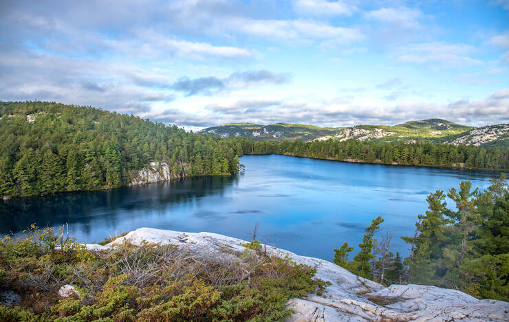 Stunning view of turquoise lake surrounded by white rock mountains and trees