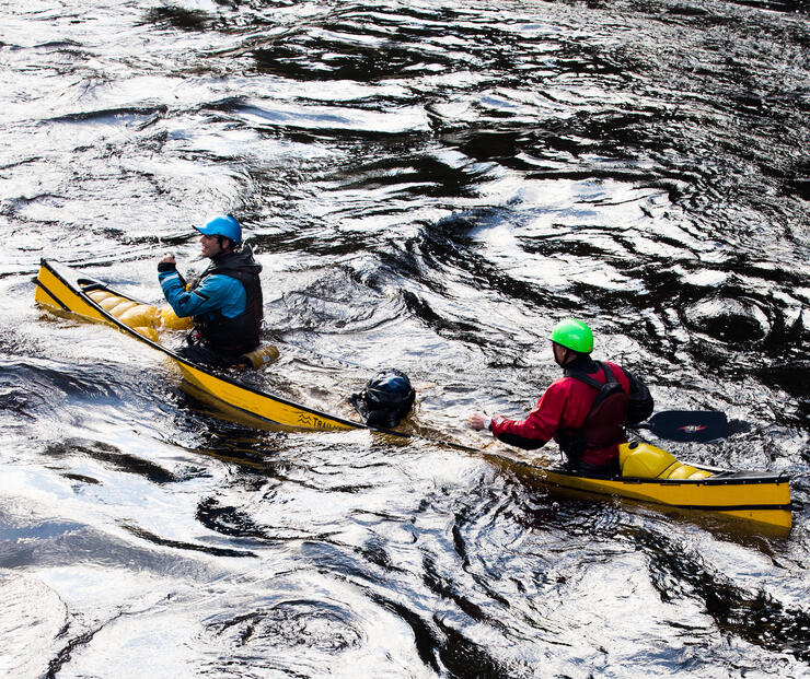Two paddlers in water-filled canoe 