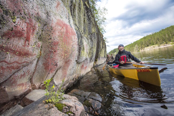 two canoeists looking a pictographs
