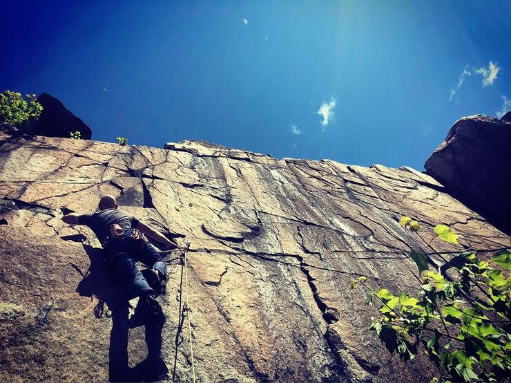 Man climbing a vertical rock face.