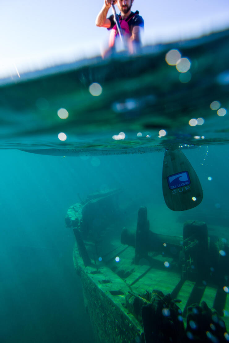 Underwater image of shipwreck with a kayaker looking down from above