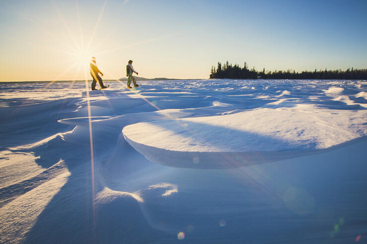 Two snowshoers walking on frozen lake