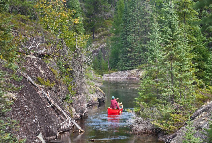 Red canoe paddling down a river 