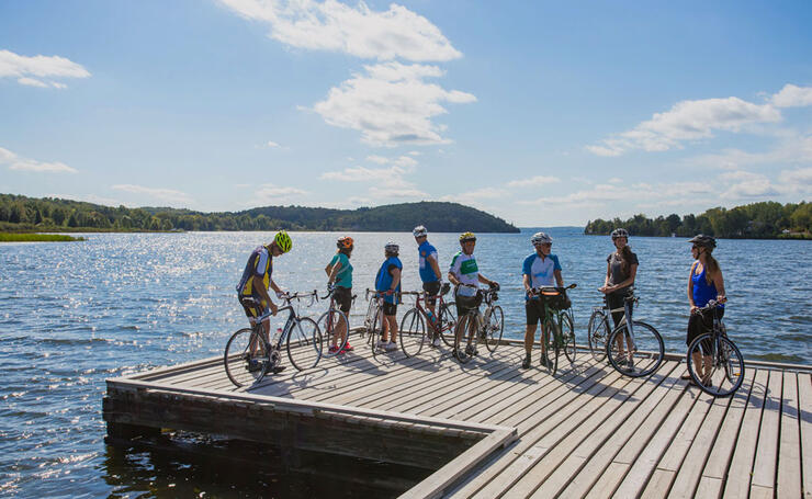 Group of cyclists on a large dock on a lake 