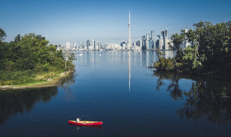 Red canoe in sheltered bay on Centre Island with CN Tower in background