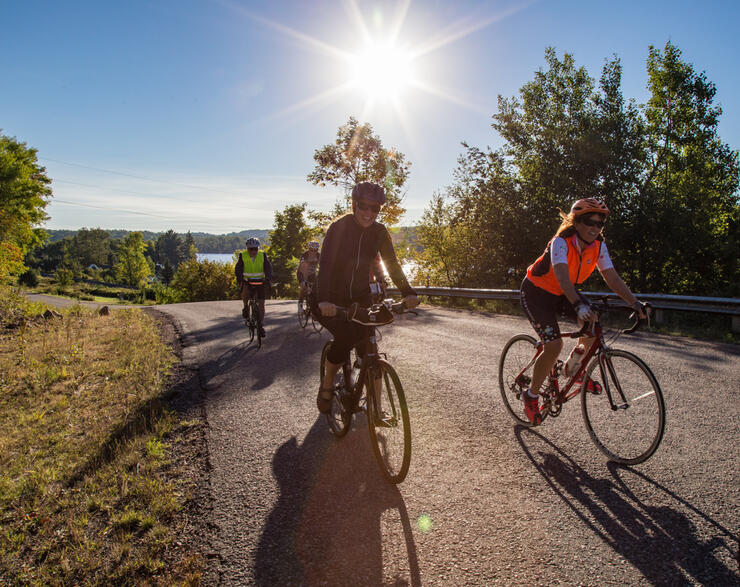 Group of cyclists riding on a road on a sunny day