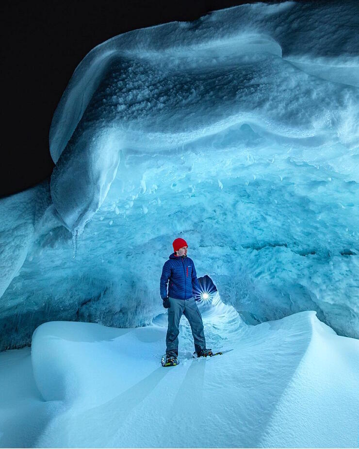 Man standing inside an ice cave.
