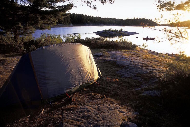 Tent on smooth rocky shoreline of the French River. 