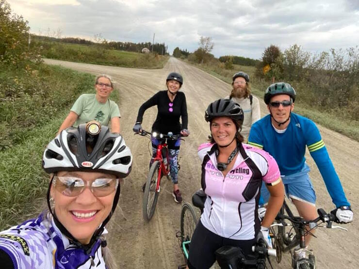 Selfie of a group of cyclists stopped on a gravel road 