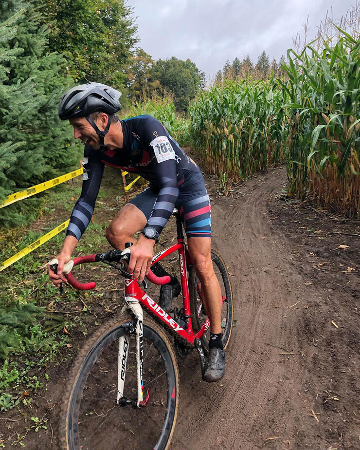 man rides a gravel bike on a muddy track through a cornfield as part of the Tour of Kincardine gravel bike race