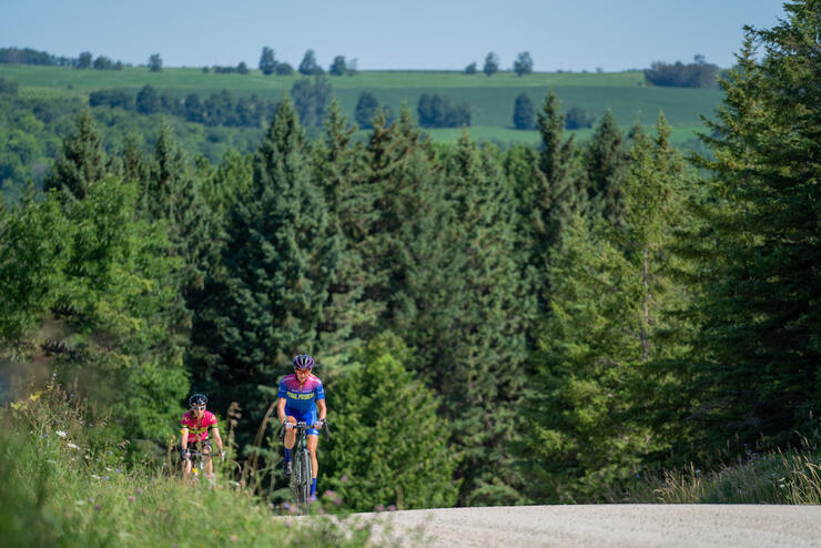 Two cyclists nearing the top of a big hill 