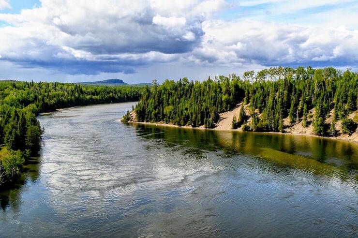 A wide calm river meandering through a beautiful Northern Ontario landscape.