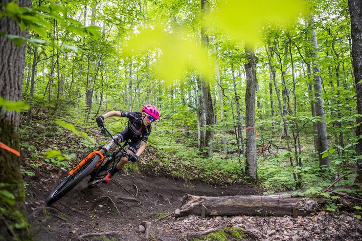 Mountain biker on banked trail in forest