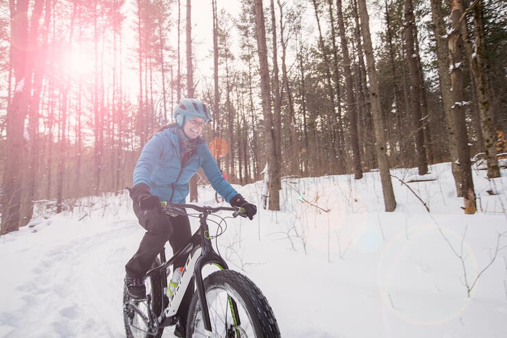 Woman riding a fat bike on snowy trail 