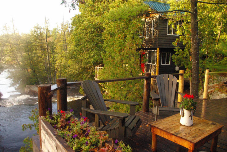 Deck and cabin overlooking a waterfalls 