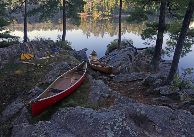 Canoes pulled up on shore next to water