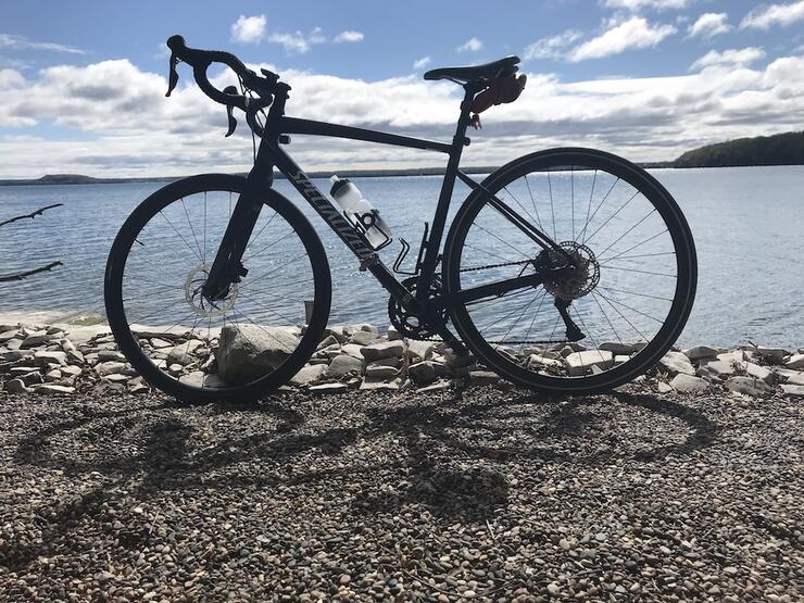 racing bicycle stands on a pebbly beach on Manitoulin Island