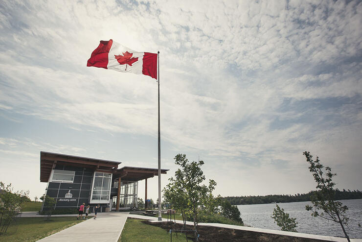 Canadian flag flies on flagpole in front of Lake of the Woods Discovery Centre