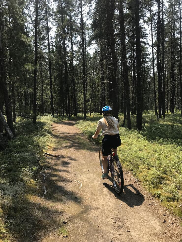 Woman biking down a trail
