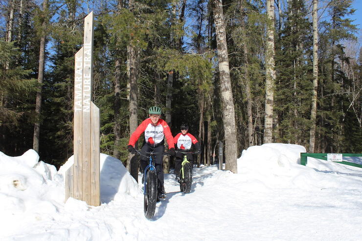 Two cyclists ride fat bikes in the winter