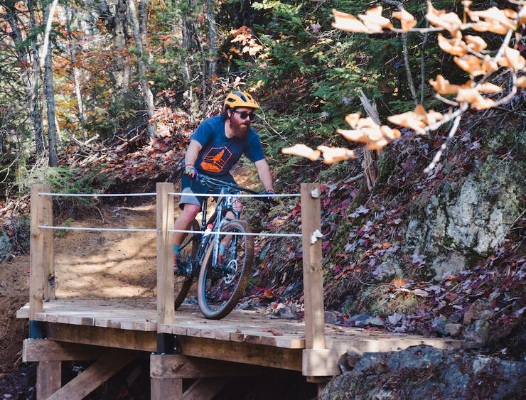 Man biking over wooden bridge