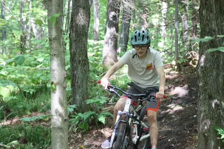 Boy rides a mountain bike through a forest