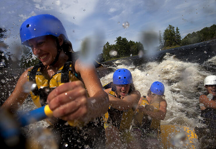 A group of women participate in whitewater rafting