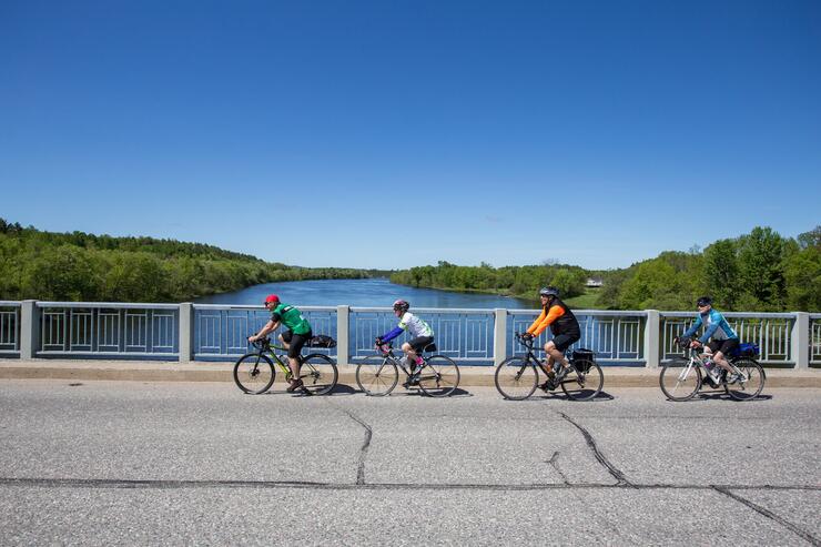 a group of touring cyclists cross the bridge in Massey, Ontario