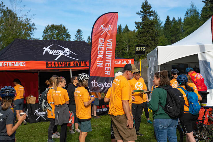 volunteers stand in front of a tent at the Shuniah Forty Miner bike race