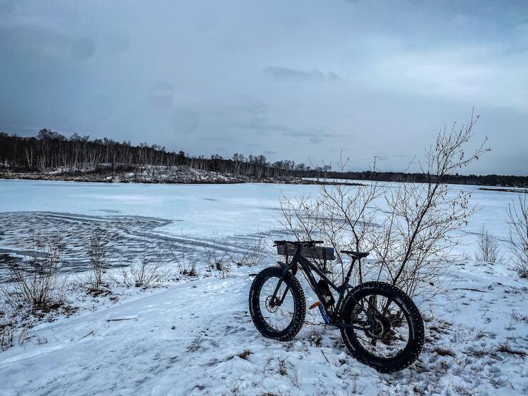 fat bike sits by the frozen water in winter at Lake Laurentian Conservation Area