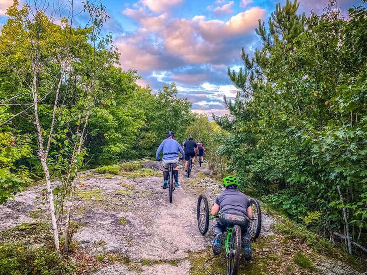 people ride along a rocky trail at Walden