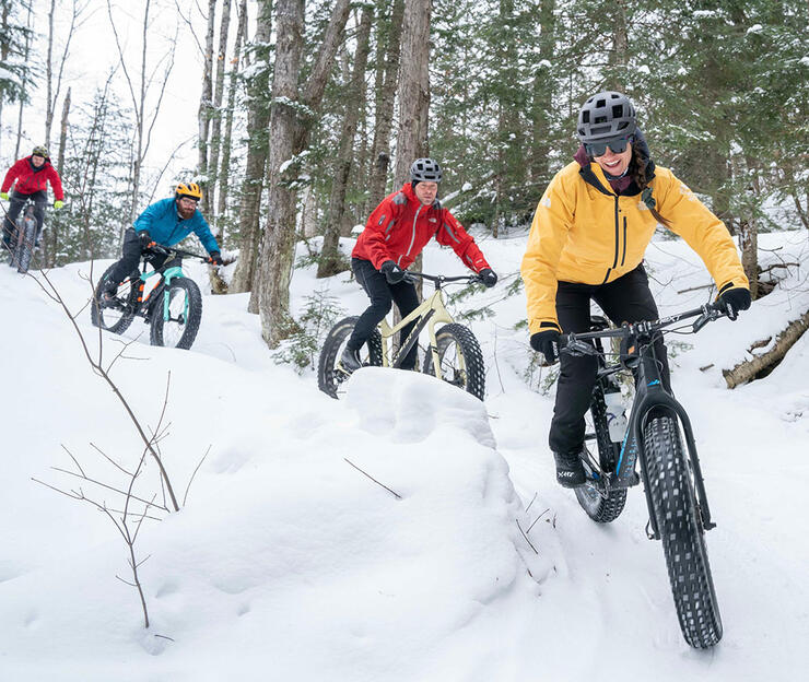 four people ride fat bikes in winter at the Algoma Highlands Conservancy
