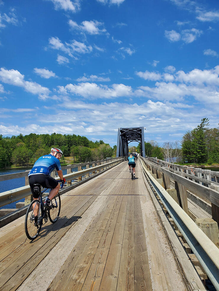 riders cross a bridge on a bike path while on a guided cycling tour
