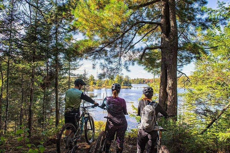 three cyclists admire the spring view from a path in North Bay