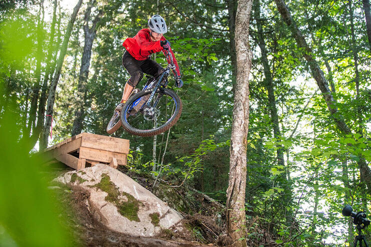 kid jumps a mountain bike on a forest trail in Algoma