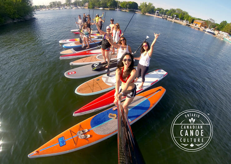 a group of women pose on standup paddleboards
