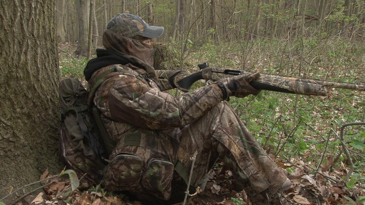 hunter sitting next to a tree