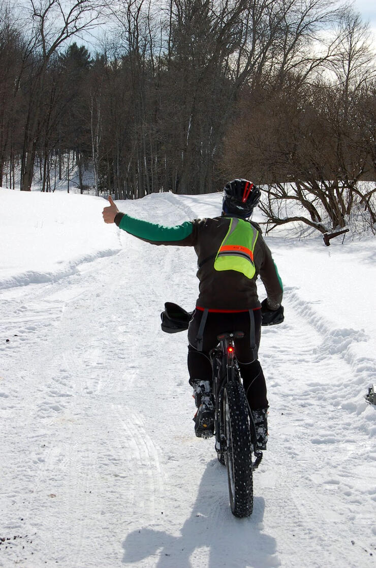 person gives thumbs up while fat biking through forest in the Wendigo Ultra