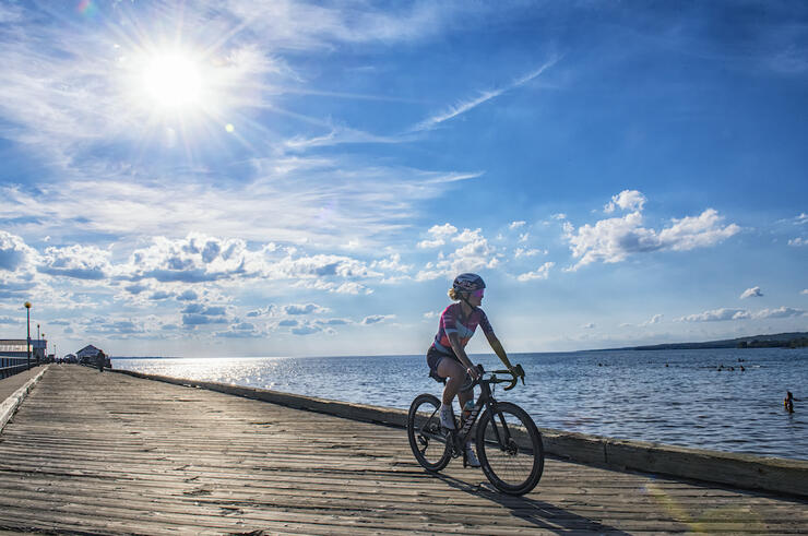 Emily riding on boardwalk next to lake.