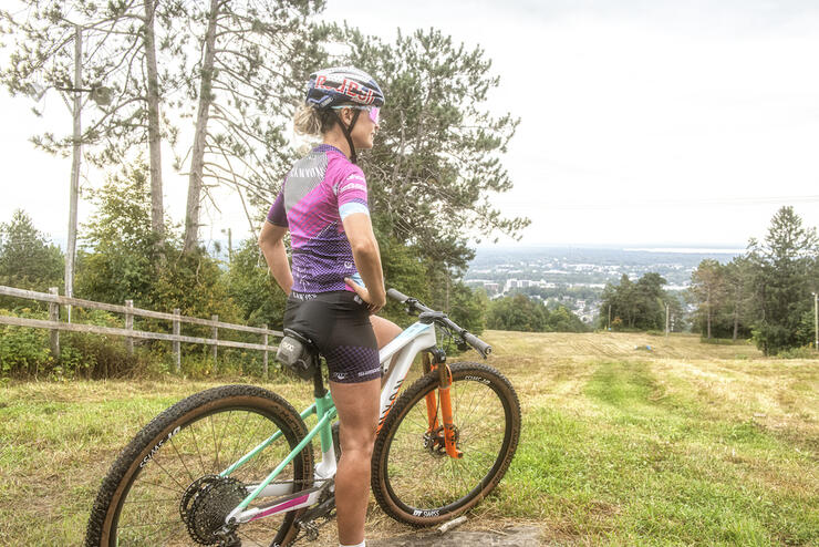 Emily Batty sitting on her bike on hill overlooking North Bay.