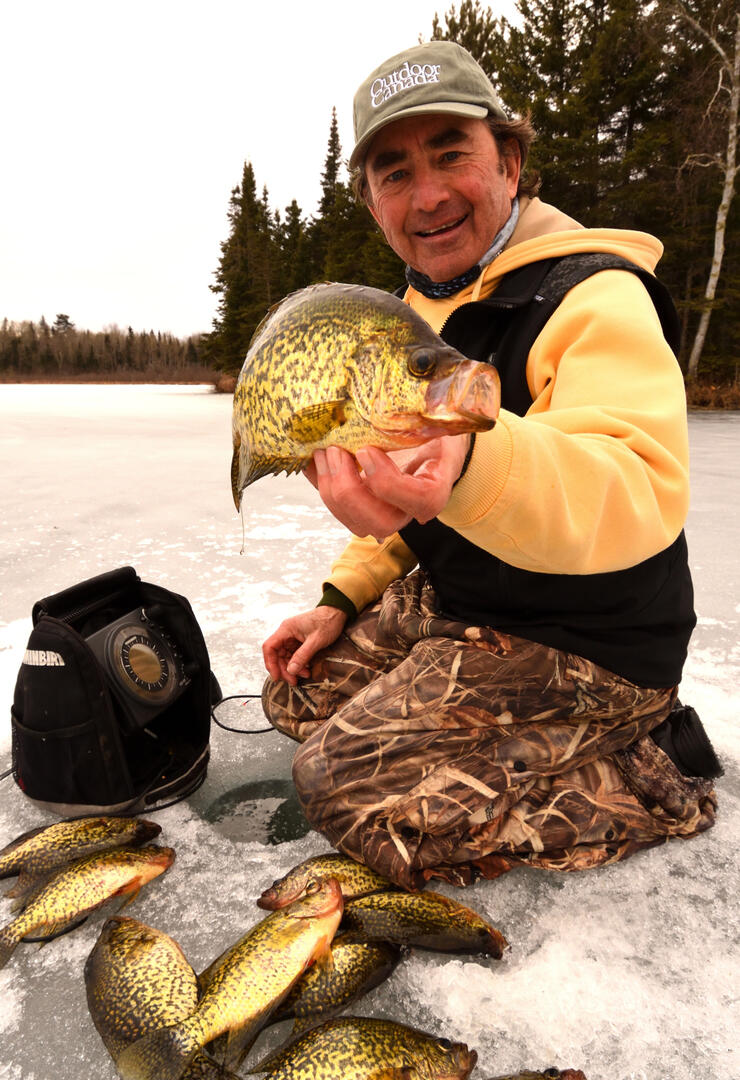 ice angler holding black crappie