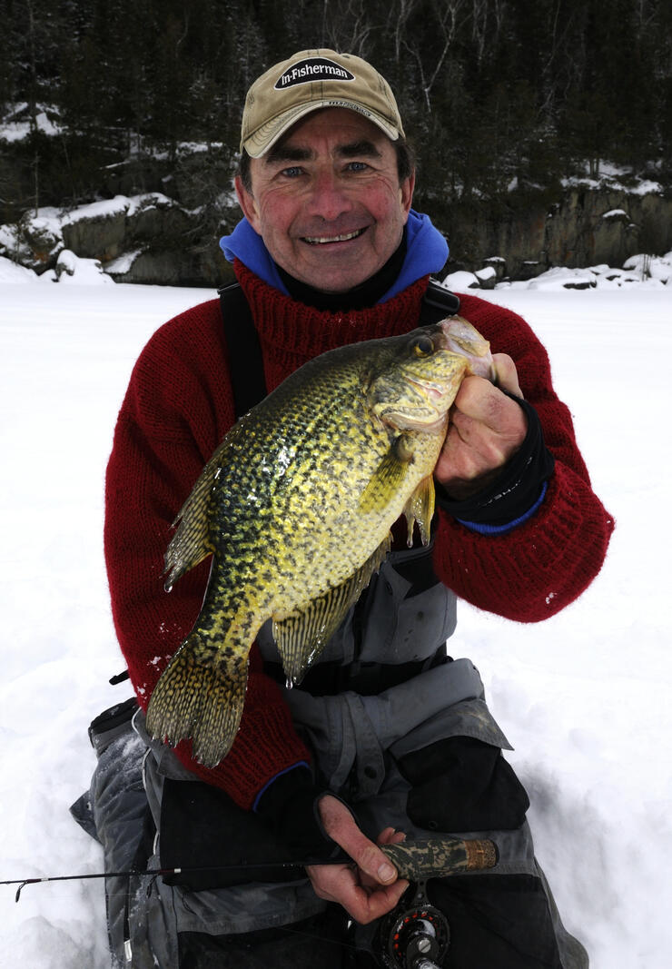 ice angler holding black crappie