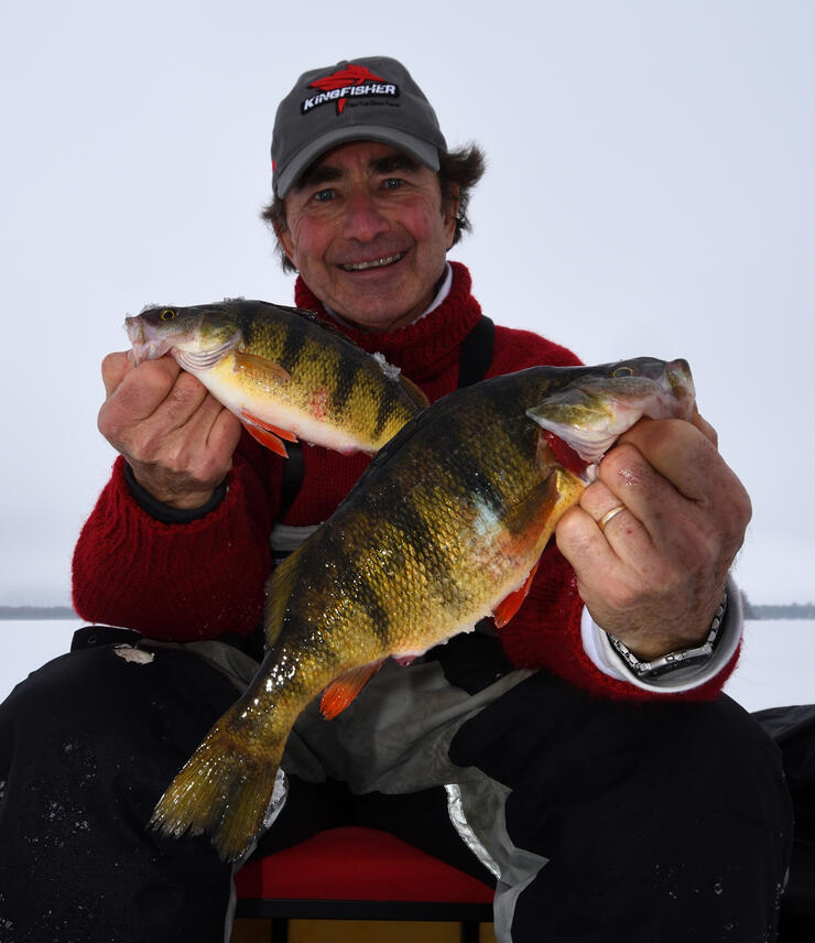 ice angler holding perch