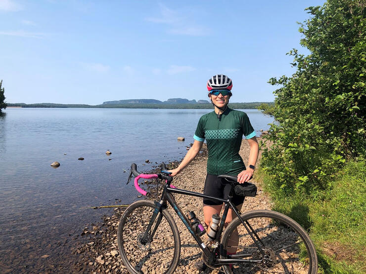 Woman cyclist poses in back of Thunder Bayâ€™s iconic Sleeping Giant landform