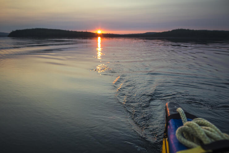 Looking back from stern of canoe into a sunset. 