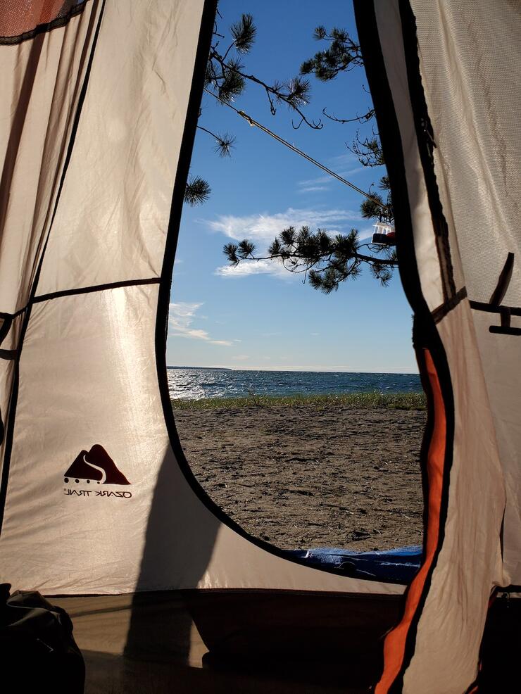 View from inside tent of beach and lake