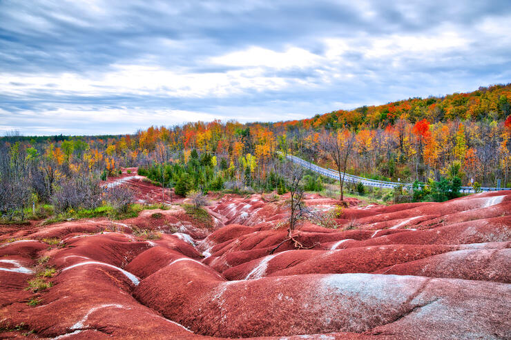 Fall colours next to red hills at one of the best places to travel in October