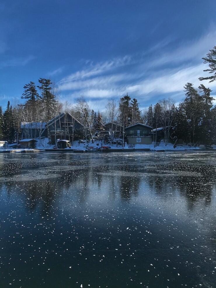 Cabins next to a frozen lake with snow all around