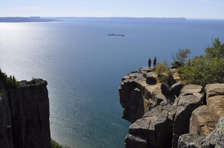 Two people standing on cliff overlooking Lake Superior