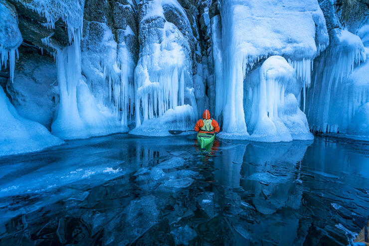 Paddler in a canoe in an ice cave